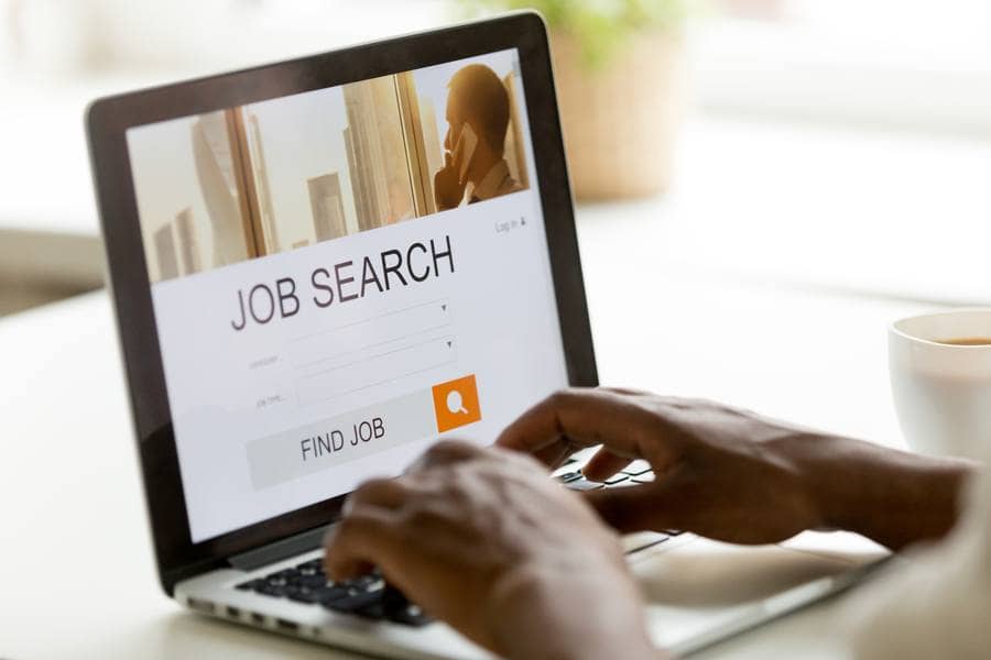 African man browsing work opportunities online using job search computer app